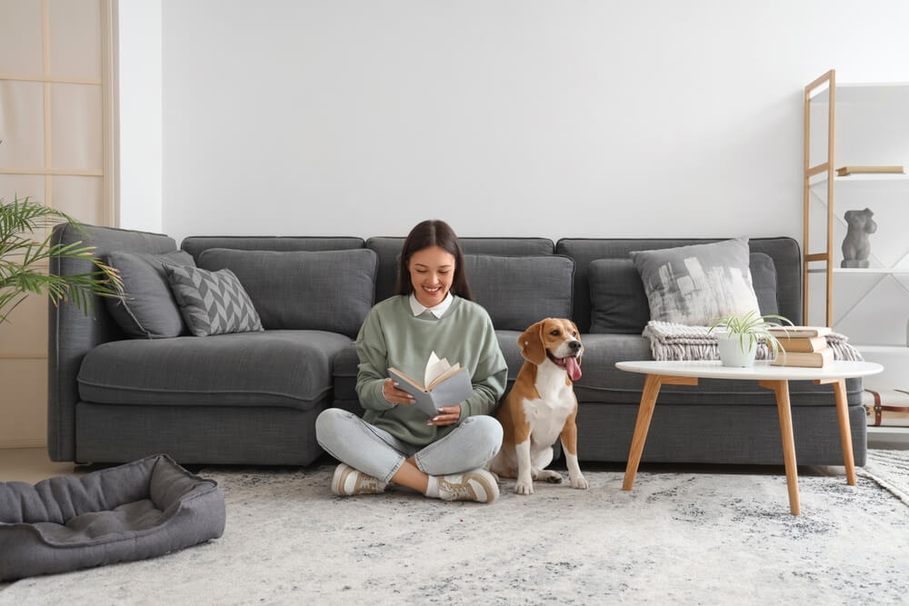  ผู้หญิงนั่งเล่นอยู่ในคอนโด Pet Friendly ซึ่งมีข้อดีที่ลงตัวกับการเลี้ยงสัตว์
